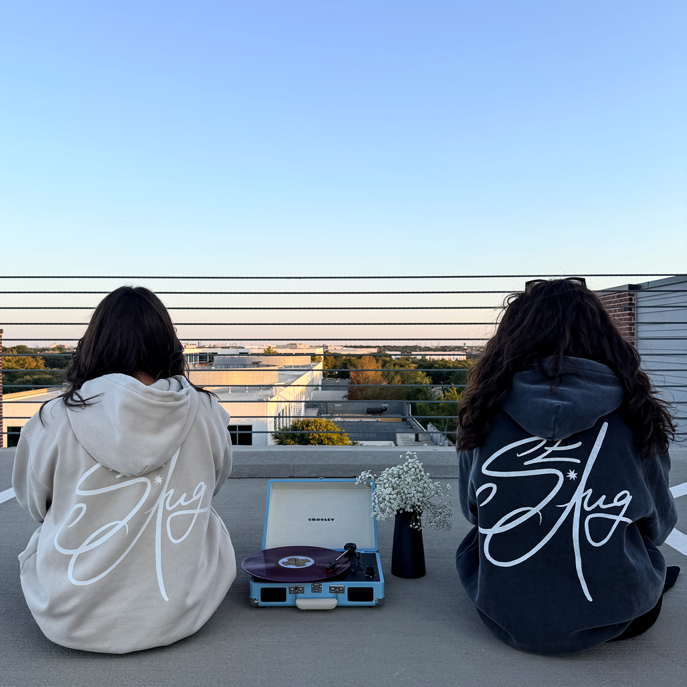 Two friends on a rooftop, in Saint August hoodies